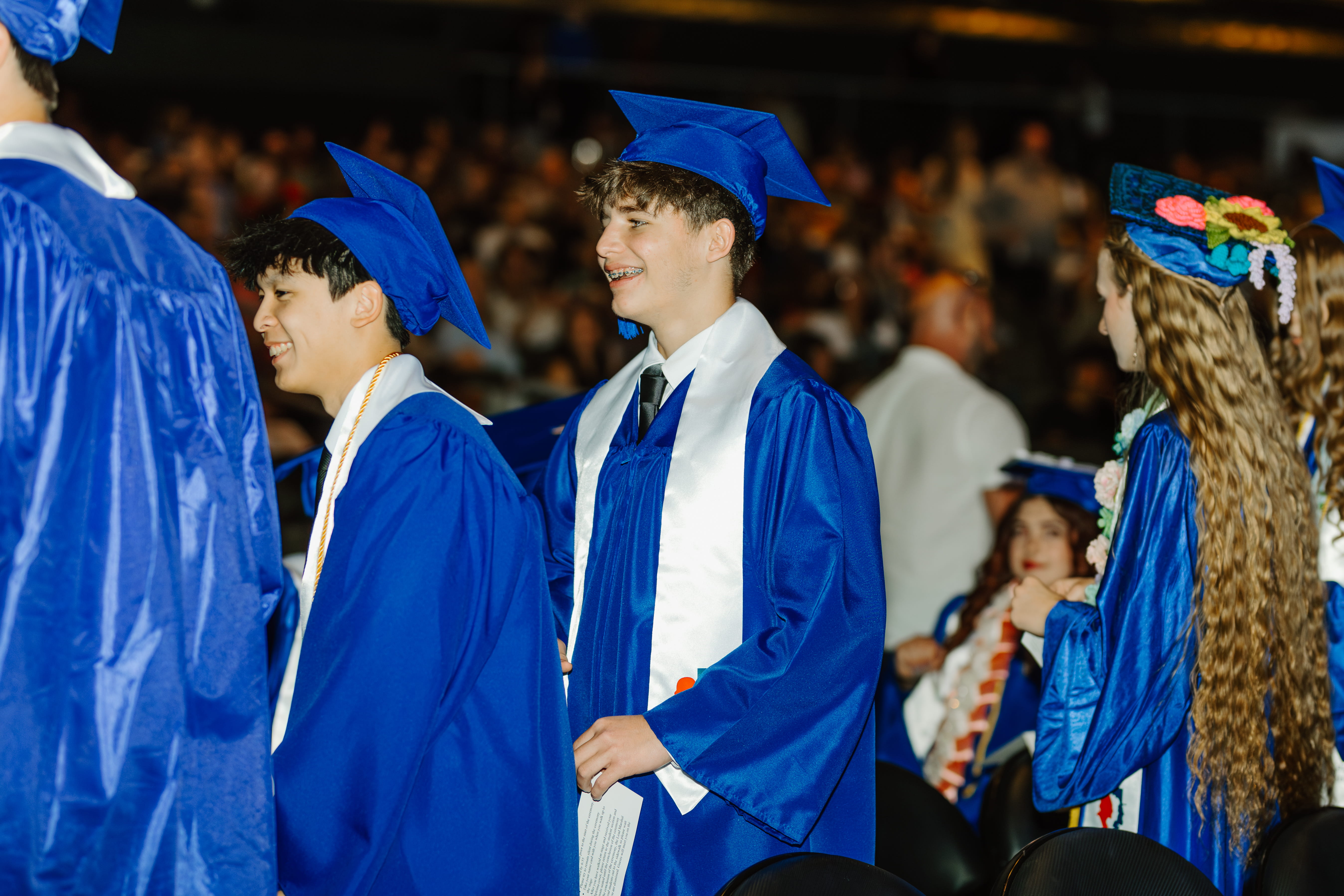 Students and faculty lined up for photo at graduation in caps and gowns