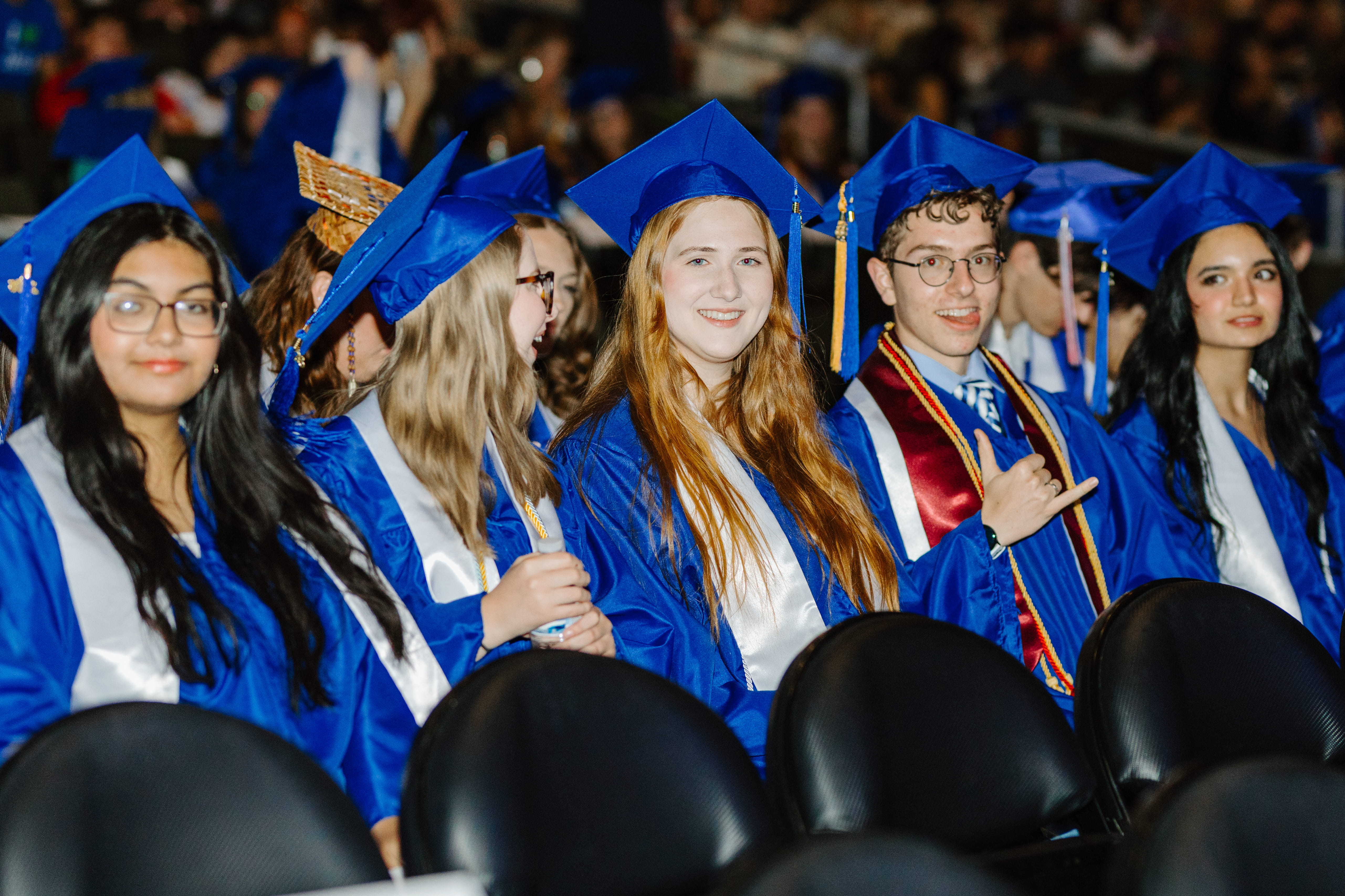 Students sitting at graduation in caps and gowns