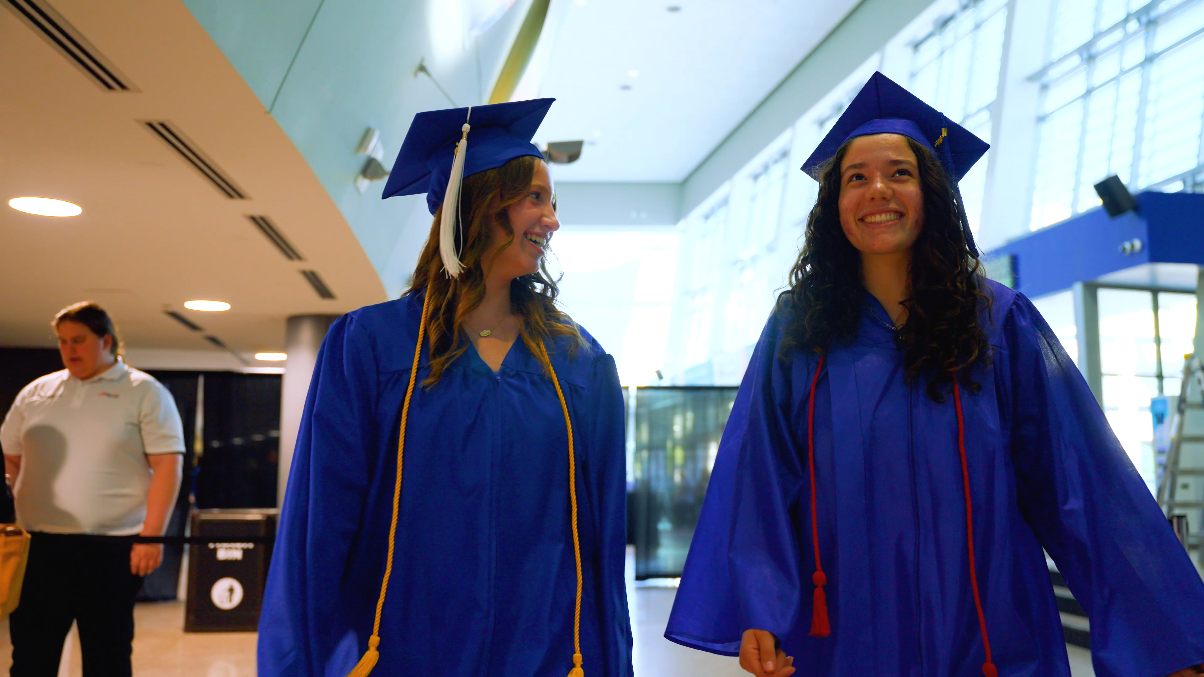 Two students wearing cap and gown at graduation